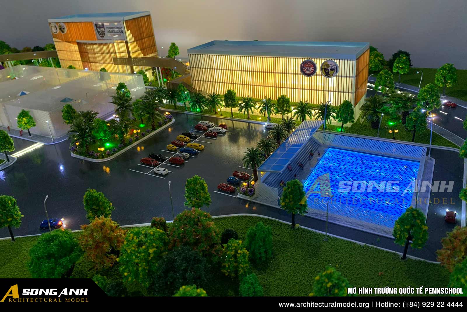 Mô hình trường học ban đêm với hiệu ứng đèn LED chiếu sáng tại khu vực hồ bơi và nhà thi đấu đa năng.