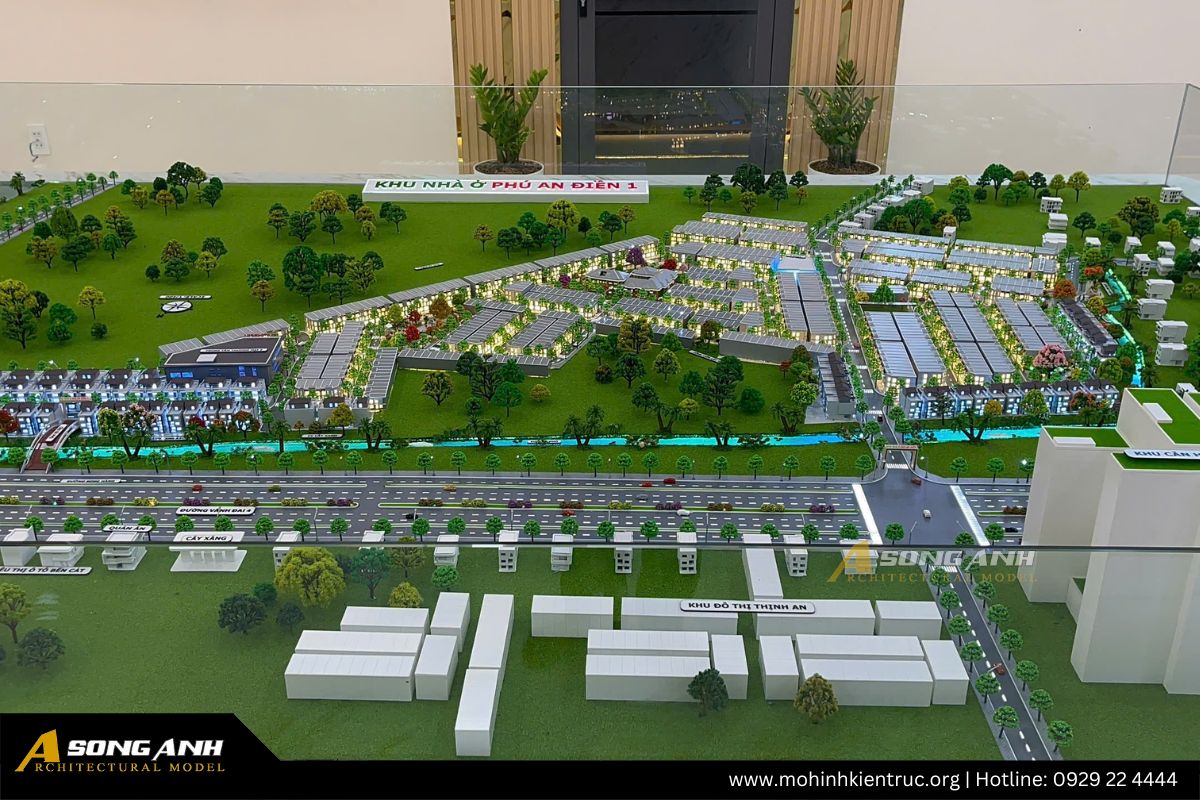 Góc chụp cận cảnh sa bàn mô phỏng trục đường giao thông chính với xe cộ và dải công viên cây xanh chạy dọc theo con kênh của dự án.