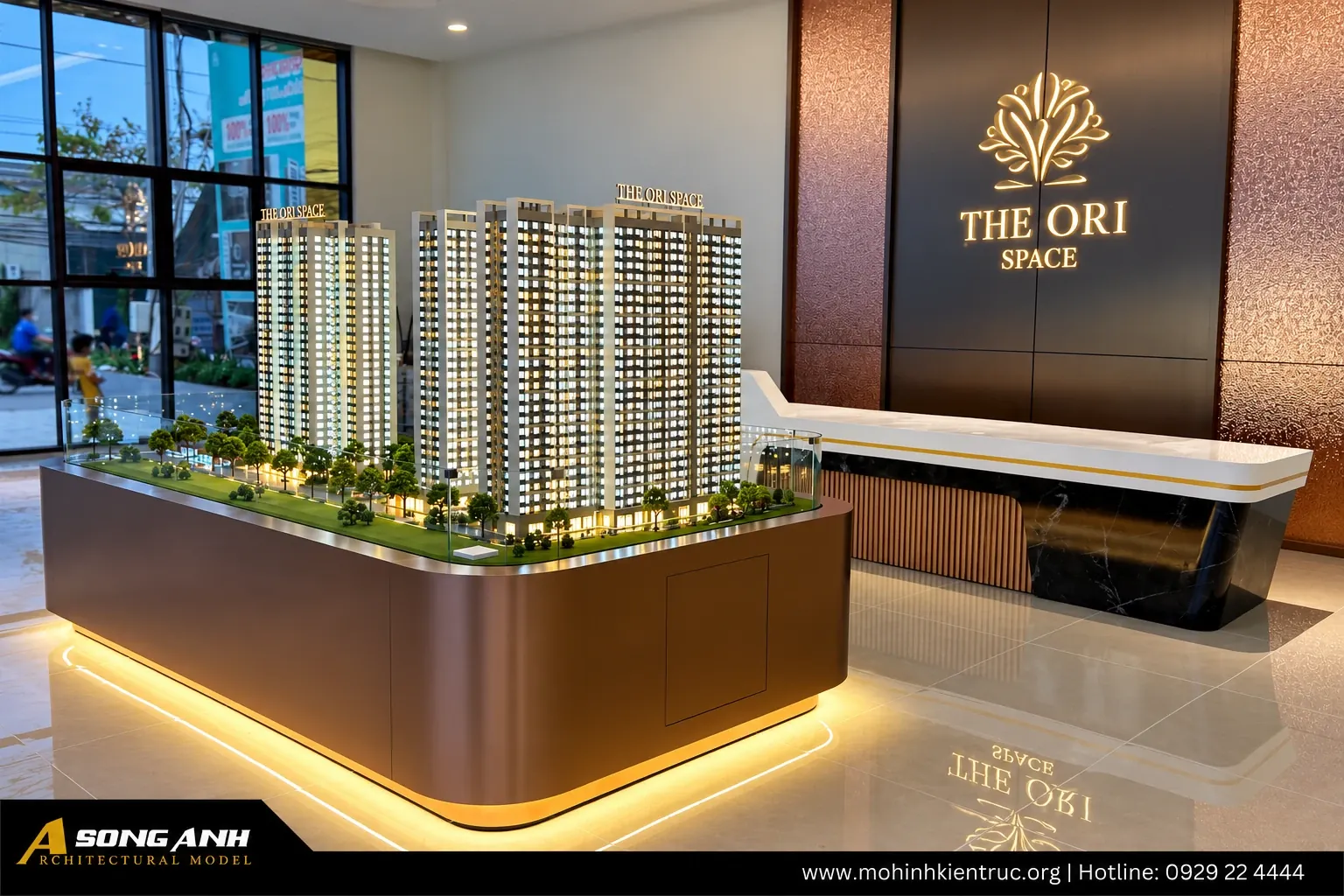 Mô hình chung cư The ORI Space Tây Ninh đặt tại sảnh nhà mẫu dự án, cạnh quầy lễ tân và vách logo